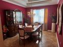 Elegant dining room featuring rich red walls, tile flooring, and a classic chandelier at 10212 Holland Rd, Riverview, FL 33578