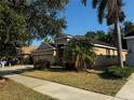Single-story tan home with a three-car garage and mature trees providing shade at 10212 Holland Rd, Riverview, FL 33578