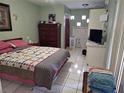 Cozy bedroom features tiled flooring, a colorful quilt on the bed, and a dresser with a wall-mounted television at 1114 27Th Se St # A, Ruskin, FL 33570