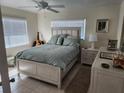 Cozy bedroom featuring a queen-sized bed, a ceiling fan, and an abundance of natural light from two windows at 1447 Lemon Bay Dr, Englewood, FL 34223