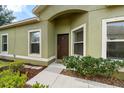 Inviting home entrance with neutral paint, manicured landscaping and decorative bushes at 1713 Trailwater St, Ruskin, FL 33570