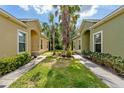 Landscaped yard with palm trees between two homes, with well-manicured lawns at 1713 Trailwater St, Ruskin, FL 33570