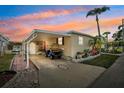 Beautiful home at dusk featuring covered parking and colorful flower garden at 18675 Us Highway 19 N # 261, Clearwater, FL 33764