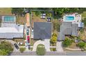 Overhead shot of a home with a large backyard and driveway, complemented by mature trees and neighboring properties at 19212 Sunlake Blvd, Lutz, FL 33558