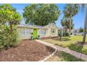 Charming single-story home featuring a vibrant green door and well-maintained front yard at 2627 8Th N Ave, St Petersburg, FL 33713