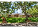 Inviting single-story home with mature trees, lush lawn, and brick mailbox enhancing its curb appeal at 2963 Cielo N Cir, Clearwater, FL 33759