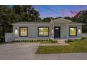 Inviting single-story home at dusk with stylish exterior lighting highlighting the freshly painted facade at 3016 N 73Rd St, Tampa, FL 33619
