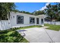 Well-maintained single-story home featuring a large driveway and lush green lawn at 3016 N 73Rd St, Tampa, FL 33619