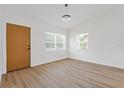A bedroom with wood-look flooring, light walls, and bright, window-filled natural light at 3151 6Th S Ave, St Petersburg, FL 33712