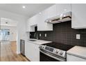 Modern kitchen featuring stainless steel appliances, sleek white cabinets, and black tiled backsplash at 3151 6Th S Ave, St Petersburg, FL 33712