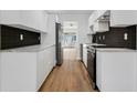 Modern kitchen featuring white cabinets, stainless steel appliances, and black tile backsplash at 3151 6Th S Ave, St Petersburg, FL 33712