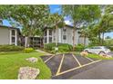 Well-maintained condo building with landscaped grounds, palm trees, and accessible parking, offering a welcoming curb appeal at 3399 Mermoor Dr # 301, Palm Harbor, FL 34685