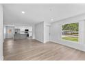 Open-concept living room with hardwood floors and an attached modern kitchen at 3910 W Iowa Ave, Tampa, FL 33616