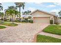 A brick driveway leads to a well-maintained home with a two-car garage and manicured landscaping at 4138 Saltwater Blvd, Tampa, FL 33615