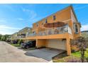 Back exterior featuring an open balcony with patio furniture, a garage, and parking area at 456 Bayou Village Dr, Tarpon Springs, FL 34689