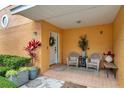 Inviting front porch with cozy seating, decorative plants, and a welcoming wreath on the front door at 456 Bayou Village Dr, Tarpon Springs, FL 34689
