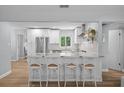 Bright kitchen featuring a granite countertop island with seating, stainless steel appliances, and modern white cabinetry at 608 Betmor Ln, Palm Harbor, FL 34683