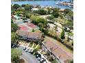 Scenic aerial view of townhouses near a lake, tennis courts, and community features at 6231 Bayside Key Dr, Tampa, FL 33615
