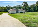 Single-story home featuring a long driveway and well-manicured front lawn at 7206 River Country Dr, Weeki Wachee, FL 34607