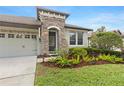 Close up of the entrance, beautiful landscaping and a three-car garage at 8015 Hampton Glen Dr, Tampa, FL 33647