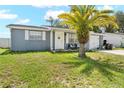 Charming home featuring a well-manicured lawn, a palm tree and a cozy front porch at 9126 Greenbriar Ln, Port Richey, FL 34668