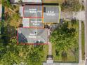 Aerial view of property featuring a main house, in-law suite, screened porch, 2 car garage, and tree-filled landscaping at 1021 15Th St, Palm Harbor, FL 34683