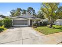 Single Gathering home boasts a screened garage, well maintained landscaping, and a beautiful lawn at 11446 Sinatra Ct, New Port Richey, FL 34654