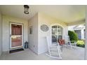 Inviting covered front porch featuring rocking chairs and a decorative front door at 11446 Sinatra Ct, New Port Richey, FL 34654
