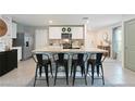 The kitchen has bar seating, stainless appliances, and modern white cabinets at 13734 Whiskey Daisy Dr, Dade City, FL 33525