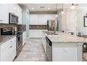 Well-lit kitchen featuring stainless steel appliances, ample cabinetry, and granite countertops at 17847 Althea Blue Pl, Lutz, FL 33558