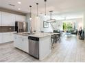 Open concept living area seamlessly connects a modern kitchen to a cozy living room at 17847 Althea Blue Pl, Lutz, FL 33558