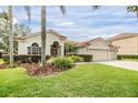 Attractive home featuring a terracotta roof, lush landscaping, and a three-car garage at 18002 Avalon Ln, Tampa, FL 33647