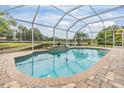 Sparkling screened-in pool overlooking a tranquil pond, creating a relaxing backyard retreat at 18002 Avalon Ln, Tampa, FL 33647