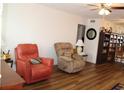 This living room features hardwood floors, a ceiling fan and two comfortable recliners at 2020 World Parkway Blvd # 12, Clearwater, FL 33763