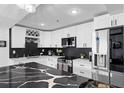 Modern kitchen features sleek white cabinets, stainless steel appliances, and a black marble countertop island at 219 4Th N Ave # 201, St Petersburg, FL 33701
