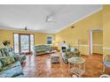 Bright living room features tropical themed furniture and a cozy fireplace at 3224 Hilary Cir, Palm Harbor, FL 34684
