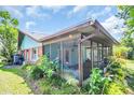 Back exterior with screened in patio and view of well maintained backyard at 3224 Hilary Cir, Palm Harbor, FL 34684