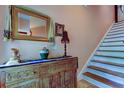 Hallway featuring a decorative wood cabinet with mirror and staircase at 3406 Hollyhock Way, Tampa, FL 33618