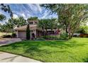 Beautiful home showcasing a lush green lawn, mature trees, and tropical landscaping at 3406 Hollyhock Way, Tampa, FL 33618