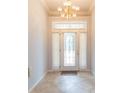 Elegant foyer with decorative tile flooring, a chandelier, and a beveled glass front door at 39055 9Th Ave, Zephyrhills, FL 33542