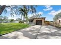 Attractive home featuring a green lawn, mature trees, a driveway, and a unique stone facade on the attached garage at 4642 29Th N Ave, St Petersburg, FL 33713