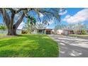 Inviting home with a well-manicured lawn, mature trees, a driveway, and a charming stone accent on the garage at 4642 29Th N Ave, St Petersburg, FL 33713