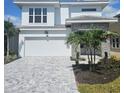 Charming two-story home with a brick driveway, two-car garage, and tropical landscaping at 648 Allora Ave, Nokomis, FL 34275