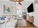 Open-concept living room with hardwood floors, a modern sofa, and a view into the dining area and kitchen at 6541 Black Mangrove Dr, Largo, FL 33773