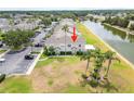 Aerial view of townhomes with a serene lake, mature trees, and ample parking at 659 Kensington Lake Cir, Brandon, FL 33511