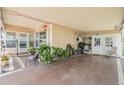 Spacious covered carport with ample seating, planters, and access to both the home and the backyard at 7053 El Conquistador St, Zephyrhills, FL 33541