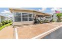 Cozy single-story home with a sunroom, a covered carport, and lovely decorations on the porch at 7053 El Conquistador St, Zephyrhills, FL 33541