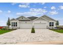 The house features a two-car garage, a brick driveway, and well-manicured landscaping at 755 Maldives Trl, Sarasota, FL 34234