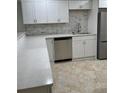 Renovated kitchen featuring stainless steel dishwasher and sink with a large kitchen counter top space at 845 S Gulfview Blvd # 110, Clearwater Beach, FL 33767