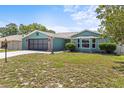 Attractive one-story home featuring an attached garage, well-kept lawn, and appealing architectural details at 10512 Red Coach St, Spring Hill, FL 34608